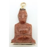 A carved sunstone pendant in the form of Guanyin with yellow metal fittings, length 3cm, 6.2g