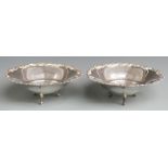Pair of Italian white metal bowls with flared and foliate rims, raised on three scroll feet, with