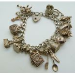 A silver charm bracelet with over 18 charms including hedgehog, apple, bible, donkey, etc