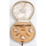 A boxed set of rolled gold buttons and a brooch set with mother-of-pearl in Henry Jones & Co box