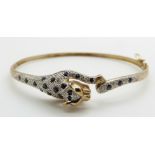 A 9ct gold bangle depicting a leopard set with sapphires and diamonds, 8.6g, 6 x 5.4cm