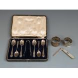 Cased set of six hallmarked silver teaspoons and tongs, two hallmarked silver napkin rings and a