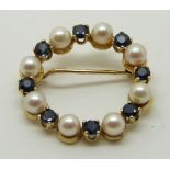 A 9ct gold brooch set with alternating pearls and sapphires, 2.2cm diameter