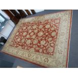Large red and beige ground rug with stylised floral design 490 x 364cm