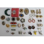 A collection of brooches including Miracle, enamel and filigree brooch, quartz brooch, porcelain