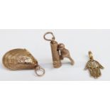 A 9ct gold woodpecker charm (3.1g), a silver gilt shell charm and a filigree hand pendant