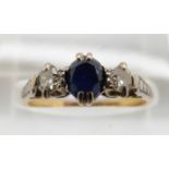An 18ct gold ring set with a sapphire and two diamonds in a platinum setting, 2.6g, size M