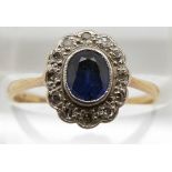 An 18ct gold ring set with an oval sapphire surrounded by diamonds, 1.9g, size M