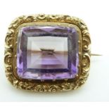 Victorian brooch/ pendant set with a large mixed cut amethyst within a scrolling border, 15.4g, 3