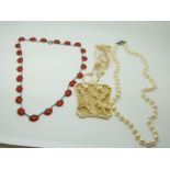 An early 20thC carved ivory pendant, a cultured pearl necklace and an other necklace