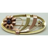 A 14k gold brooch in a stylised floral design set with a diamond and sapphire, 5.2 x 2.5cm, 7.7g