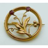 A 9ct gold brooch set with two garnets in a floral design by E.W, 1.9g