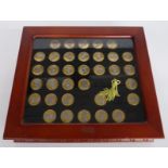 Thirty three coated USA one dollar coins in deluxe case.