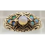 A 9ct gold ring set with opals in a scrolling setting, 3.7g, size L