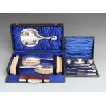 Cased hallmarked silver mounted dressing table set comprising hand mirror, four brushes and a