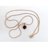 A 9ct gold necklace and pendant set with a round cut garnet, 3.3g