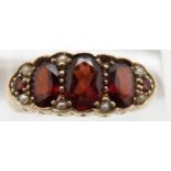 A 9ct gold ring set with five garnets and seed pearls, 3.4g, size S