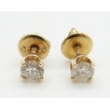 A pair of 14k gold earrings set with a diamond measuring approx 0.25ct each