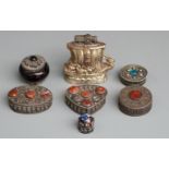 Six white metal or similar Eastern lidded pots and an Oriental style lighter formed as a boat