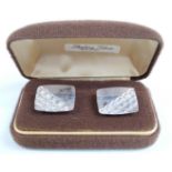 A pair of silver cufflinks with engraved decoration in original box