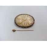 A 9ct gold stick pin and a silver brooch set with carved mother of pearl