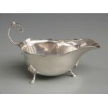 George V hallmarked silver sauce boat with shaped edge, raised on three feet, Chester 1930 maker