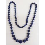 A lapis lazuli necklace of 72 graduated carved spherical beads, the largest 16mm in diameter.