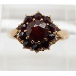 A 9ct gold ring set with an oval cut ruby surrounded by diamonds, 3.7g, size M