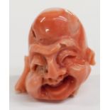 Chinese carved coral figure in the form of a laughing Buddha head, 2.2cm tall.