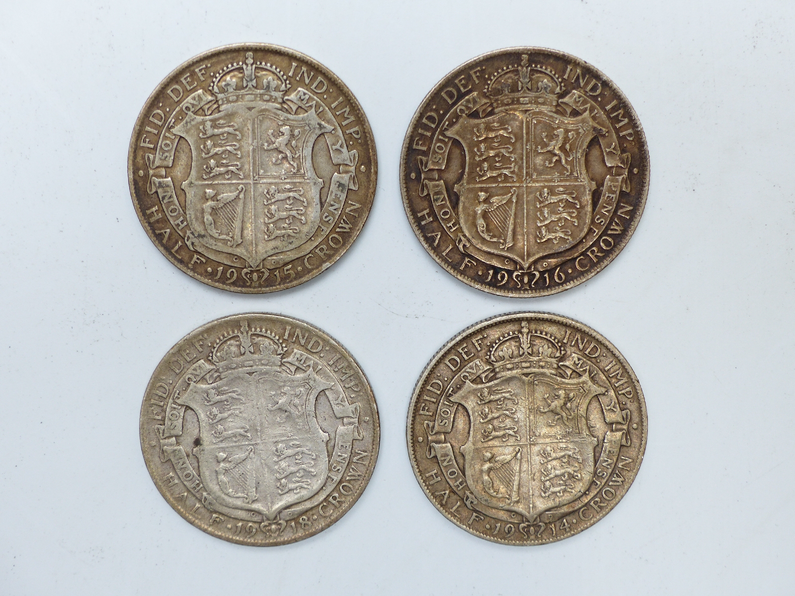 Four George V half crowns dated 1914, 1915, 1916 and 1918