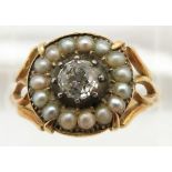 An early Victorian ring set with an old cut diamond of approximately 0.35ct surrounded by seed