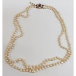 A double strand of cultured pearls with a 9ct gold clasp set with an amethyst