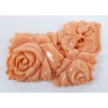 A carved coral plaque depicting roses, 4 x 2.5cm