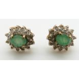 A pair of 9ct gold earrings each set with an emerald and diamonds