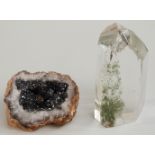 A quartz crystal containing a mineral inclusion and a geode.