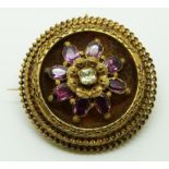 Victorian brooch set with foiled garnets and a paste stone to the centre within a border with
