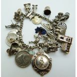 A silver charm bracelet with 20 charms including a fob, church, scooter, etc