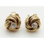 A pair of knot earrings set with a diamond measuring approximately 0.1ct to each, 1.6g