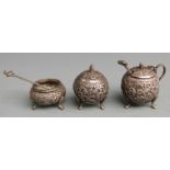 Indian or similar white metal three piece cruet with embossed decoration, height approximately