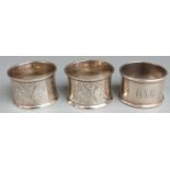 Three hallmarked silver napkin rings including a Victorian pair engraved with birds, London 1896