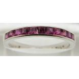 An 18ct white gold half eternity ring set with square cut rubies, 2.8g, size P