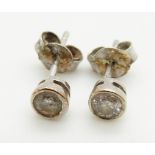 A pair of 9ct white gold earrings each set with approximately 0.15ct