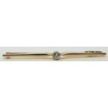 A 9ct gold bar brooch set with an old cut diamond measuring approximately 0.2ct