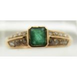 A yellow metal ring set with an emerald cut emerald and diamonds to the shoulders, 2.2g, size P