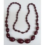 A cherry amber necklace of  52 graduated oval beads, the largest 28.9x26mm, 69g.