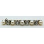A silver brooch set with alternating pearls and white sapphires