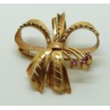 A 18ct gold pendant/ brooch in a bow set with rubies, 6.5g