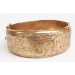 A 9ct gold bangle with engraved foliate decoration, 26g (6.2 x 5.7cm)