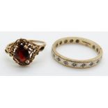 A 9ct gold ring set with a garnet and a 9ct gold eternity ring, 3.9g