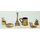 A group of 9ct gold charms including Eiffel Tower, bell, mug, boot and two others, 7.4g